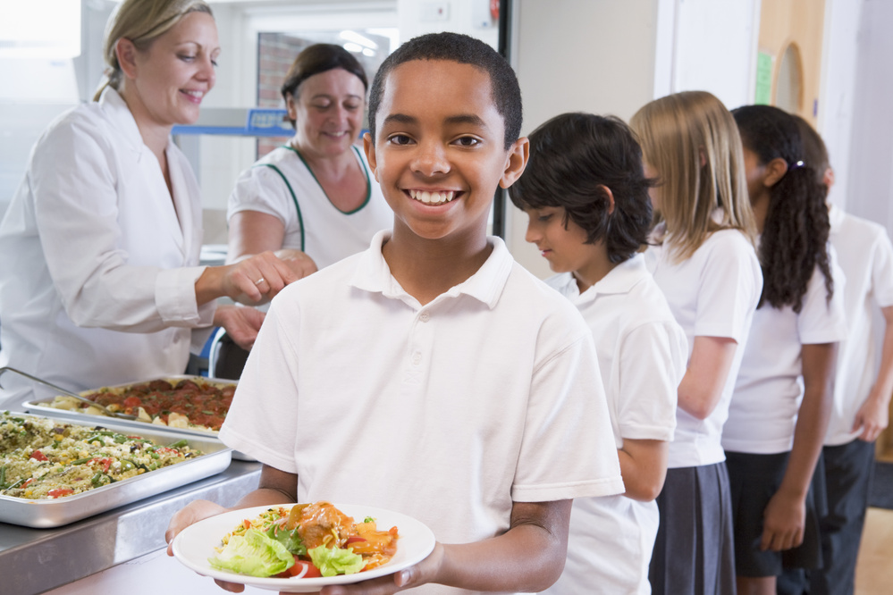 School Boy Holding Plate of Lunch in School Cafeteria